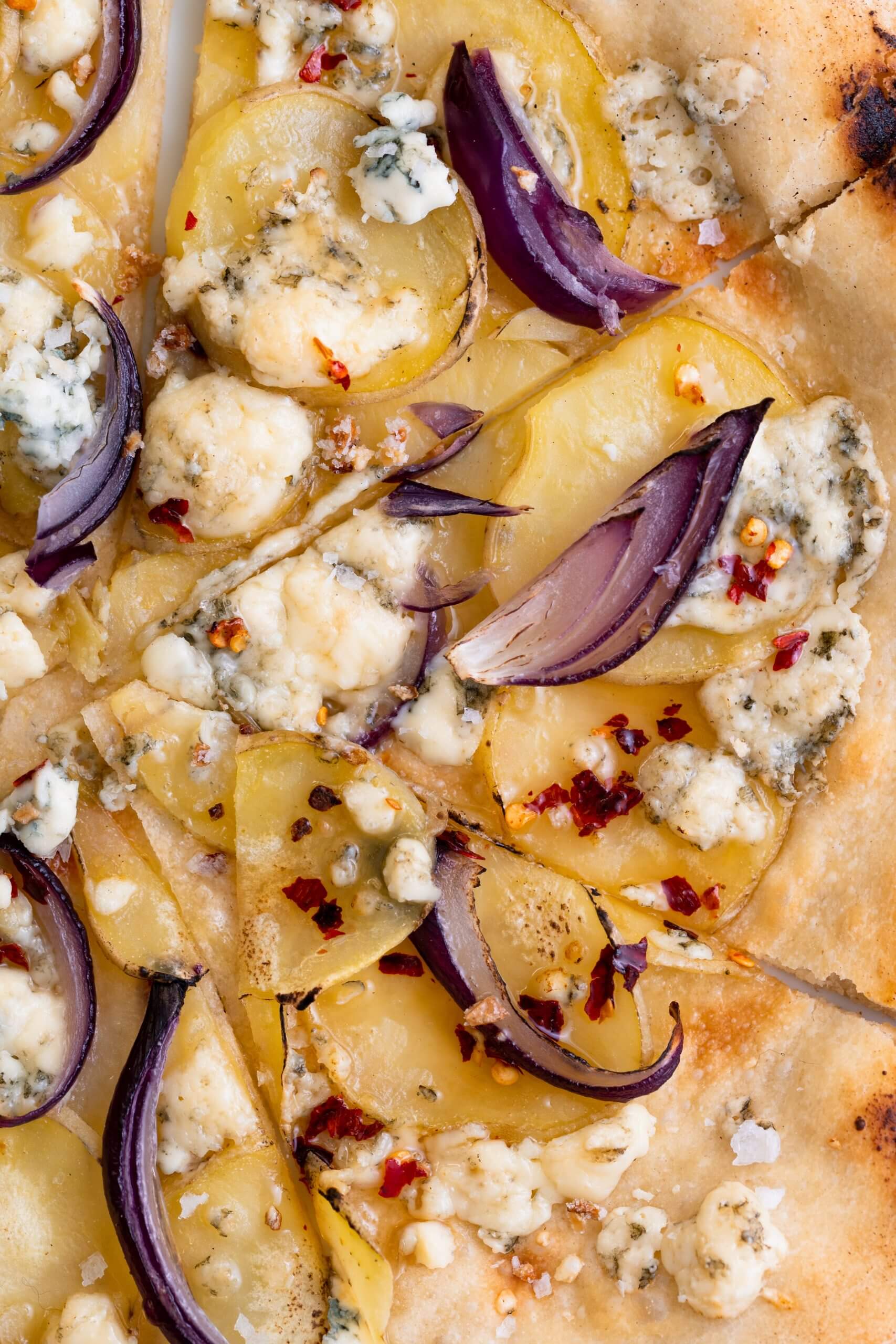 pizza met aardappel, rode ui, gorgonzola en spicy honing